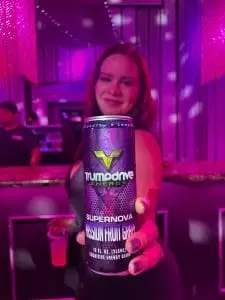 image of woman holding trumpdrive energy drink to camera